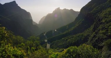 Masca Vadisi ve Gorge 'da güzel bir günbatımı, Tenerife, Kanarya Adaları, İspanya. Güneş ışığı dağ sıralarının arasından doğuyor. Harika bir manzara. Yüksek kalite el kamerası atışı..