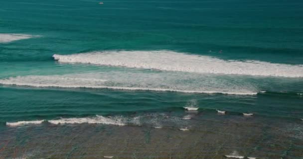 夏日阳光明媚的时候 海浪冲向了海滩 在巴厘岛绿碗海滩上冲浪 蓝绿色水晶清澈的水 宁静的大自然背景 无法辨认的游客 — 图库视频影像