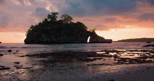巴厘岛的克里斯托湾海滩上乌云密布 天空五彩斑斓 落日时 在浅水平静的海水中 陡峭的轮廓 放松平静假期的概念 — 图库视频影像
