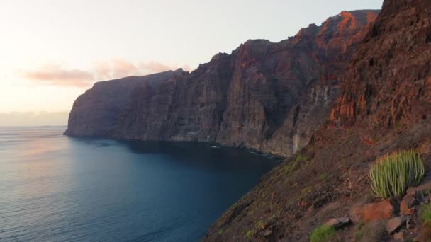 Okyanus Suyunun Üzerinde Renkli Günbatımı Işığı Dalgalar Kayalık Dağ Kıyısına — Stok video