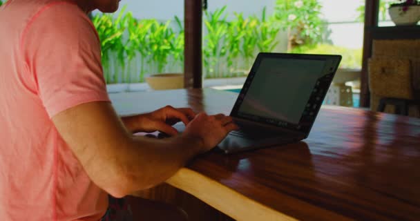 庭のノートパソコンに入力する人の手のクローズアップ 男性は Webブラウザ上で電子メールやサーフィンを送信するためのコンピュータキーボードで動作します 木製テーブル — ストック動画
