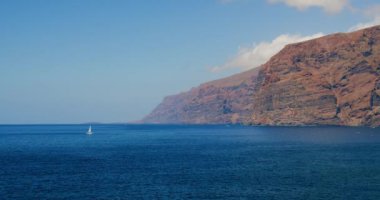 Lonely sailing yacht in the blue waters of the ocean. Against the blue sky. The concept of active recreation on the water and yachting. Canary Islands, Tenerife. Nobody.