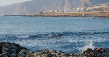 Punta Juanita ya da Punta Blanca plajı Puerto de Santiago, Tenerife, Kanarya Adaları, İspanya. Dalgalar çekildi. Los Gigantes rıhtımı manzaralı