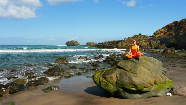 美丽的自由女人坐在沙滩上沉思 海洋挥发泡沫 莲花体位药物瑜伽阿萨那每天平衡昆达里尼能量日常练习健康注意 — 图库视频影像
