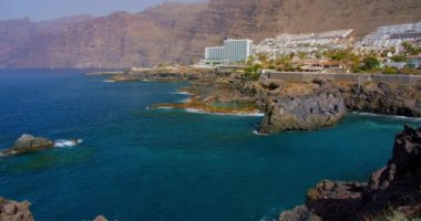 Los Gigantes Kayalıkları. Puerto de Santiago 'daki volkanik doğal havuz, Tenerife, Kanarya Adaları' nın güneyindeki kayalara vuran dalgalar doğal olarak. Güneşli bir gün, sakin bir manzara, sıcak bir hava..