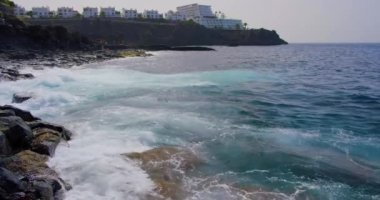 Siyah kayalık volkanik plaj, okyanusta köpüren ve sıçrayan dev dalgalar. Puerto de Santiago, Tenerife. Dalgaları kapat.
