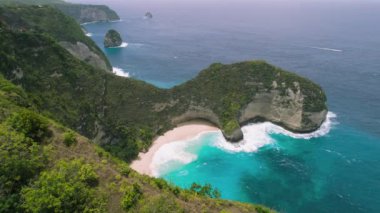 Breathtaking tropical Kelingking Beach Nusa Penida Island Bali. Scenery lagoon, sand shoreline and mountain cliff in ocean on nature background. Indonesia. High quality 4K footage.