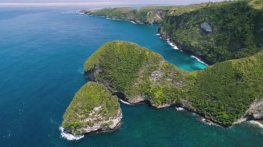 Tropical rocky coastline of island Nusa Penida Bali Indonesia. Manta Bay or Kelingking Beach is famous tourist attraction, must visit place. Aerial drone flight.