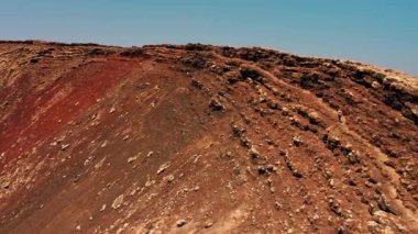 Fuerteventura, Kanarya Adası, İspanya 'daki muhteşem hava manzarası volkan krateri Calderon Hondo' yu korudu. Volkanik terk edilmiş kraterin iç yüzeyinde yürüyen bir kadın turist. İnsansız hava aracı videosu. Kuru Temizle