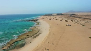 Grandes, Corralejo 'yu oynuyor. Güzel turkuaz okyanus suyu ve beyaz kum. Şeffaf dalgalar. Turist beldesi. Seyahat güzergahı. Corralejo Büyük Plaj Ulusal Parkı, Fuerteventura, Kanarya
