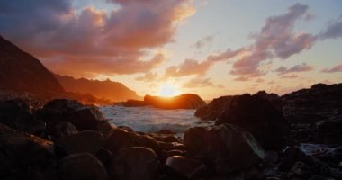 Atlantik Okyanusu gün batımı. Manzaralı okyanus kayalık volkanik plajı. Deniz dalgaları taşlara çarpıyor. Tenerife 'nin kuzeyinde, Kanarya Adaları, İspanya. Kimse..
