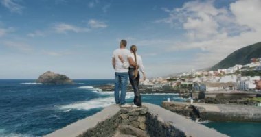 Beyaz çift Tenerife sahilinde birbirlerine sarılıyorlar. Gorachico.