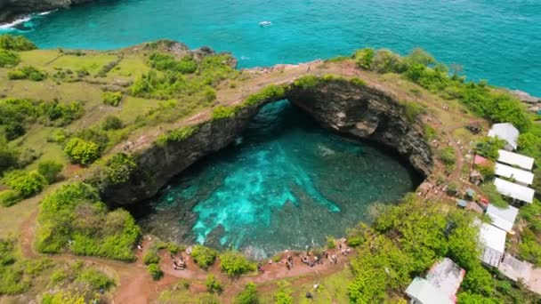 ヌサペニダ島バリ島壊れたビーチ 人気の観光地 東南アジアへの旅行 海の海岸線で珍しい自然橋の空中ビュー — ストック動画