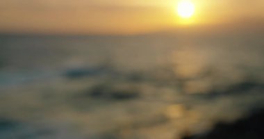 Blurred sunset sky and glimmering sea surface with sun reflected in water. Background.