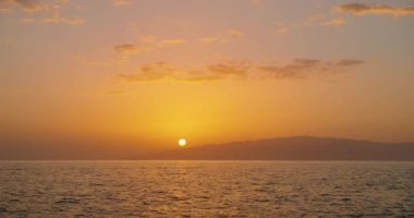 La Gomera adası ve okyanus üzerinde ufuktaki güneş diski. Deniz suyuna ışık yansıyan gün batımı turuncu gökyüzü. Tenerife 'den görüntü. Statik görüntüler.