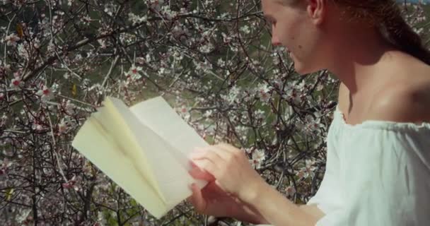 Young Woman Reading Diary Blossoming Cherry Tree Backlit Close Girl — Wideo stockowe