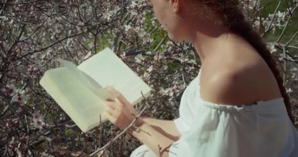 Young Woman Reading Diary Blossoming Cherry Tree Backlit Close Girl — Vídeo de Stock