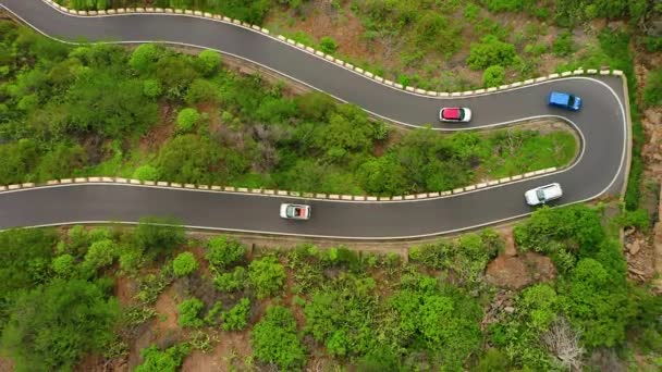 空中俯瞰高山蛇形道路 有许多移动的汽车 有许多急转弯的上坡路 汽车沿着山路行驶 — 图库视频影像