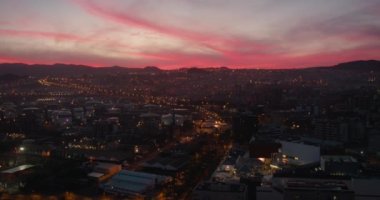 Başkent Santa Cruz de Tenerife 'nin gece manzarası bir gökdelenin yüksekliğinden. Bulutlu kırmızı gökyüzü ile kırmızı gün batımı gökyüzü. Şehir ışıkları.