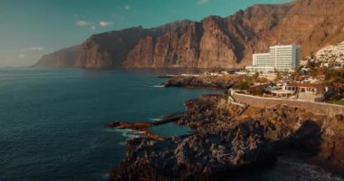 Tenerife Kanarya Adaları 'nda doğal okyanus yüzme havuzu. Charco de Isla Cangrejo. Gün batımında Los Gigantes uçurumlarının muhteşem manzarası. Puerto Santiago Kasabası.