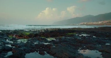 Gün batımına karşı dalgalı, bulutlu, mavi gökyüzü. Punta Juanita, Tenerife Kanarya Adaları İspanya 'daki volkanik taşlar.