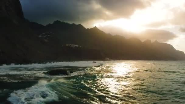 海浪的余晖冲刷着岩石的海滩 夕阳西下山的轮廓 热带地区没有人天生的海景 加那利群岛 特内里费天堂岛 — 图库视频影像