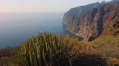 Uçuşlar uçurumlar, derin mavi okyanuslar, büyük uçurumlar Acantilados de Los Gigantes, Tenerife, İspanya. Beyaz sis. Huzur. Issız kayalık volkanik dağlar. Kimse..