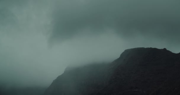 テネリフェ島の灰色の雨雲で覆われた高ロスギガントスの崖の上 霧の危機にある火山の頂上を眺めることができます 天気の良いロッキービーチは 天気の良い日に重い雲が付いています ストーム — ストック動画