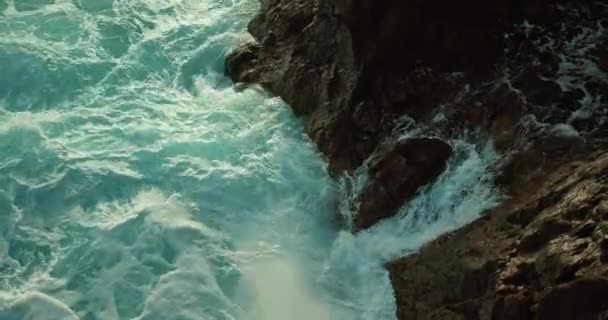 海浪从岩石的裂缝中喷涌而出 缓慢运动的海水发泡和飞溅 原始的火山海岸上有海水断裂 后续行动 — 图库视频影像