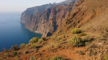 Uçuşlar uçurumlar, derin mavi okyanuslar, büyük uçurumlar Acantilados de Los Gigantes, Tenerife, İspanya. Beyaz sis. Huzur. Issız kayalık volkanik dağlar. Kimse..