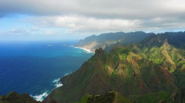 Anaga dağları hava manzaralı. Tenerife Kanarya Adası, İspanya. Derin mavi okyanus suları. Kıyı manzarası. Karanlık orman. Bulutlu bir gökyüzü. Seyahat güzergahı. Tatiller.