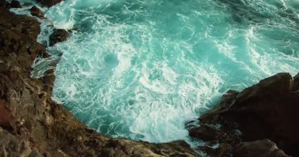 海浪冲刷着岩石海岸缓慢运动的海水泡沫 普里斯丁火山海滩特写电影视图 — 图库视频影像
