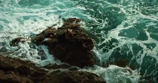 海の波は岩の海岸のゆっくりした動きの海水泡を洗います プリスティン火山ビーチクローズアップ映画ビュー — ストック動画