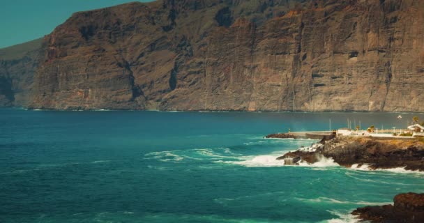 海岸線の崖や海の景色カナリア諸島のテネリフェ島のAcantilados Los Gigantes 動きの遅い海の波が晴れた日に岩の多い海岸に飛び散る — ストック動画