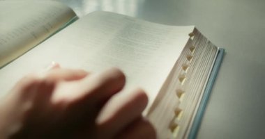 Genç adam evde kitap okuyor. Sayfalar dolusu kağıda yakın çekim yap. İnternet olmadan karantina süresince bilgi.