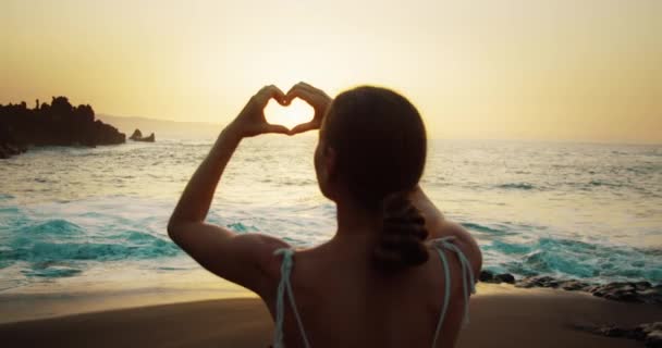 Kobieta Plaży Pokazuje Symbol Serca Dłońmi Zachodzie Słońca Letnie Wakacje — Wideo stockowe