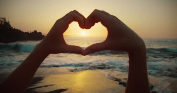 Γυναίκα Στην Παραλία Δείχνει Σύμβολο Της Καρδιάς Χέρια Στο Χρυσό — Αρχείο Βίντεο