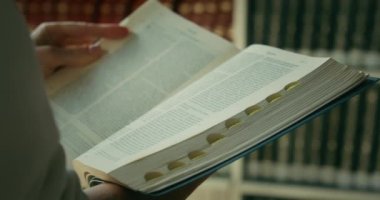 Kadın kütüphanede kitap okumayı kendi kendine öğrendi. Eğitim kavramını öğreniyorum. Ağır çekimde yakın çekim.