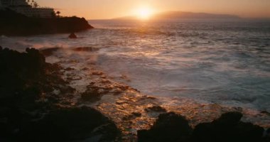 Karanlık çöktüğünde okyanus dalgalarının çarptığı ve su sıçrattığı Rocky Plajı 'nda gece çöker. Puerto Santiago kasabası, Tenerife. Kanarya Adaları İspanya Avrupa.