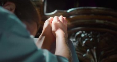 Kilisenin karanlık bir köşesinde Tanrı 'ya dua eden bir kadın. Kurtarıcı İsa 'ya dua etmek için katlanmış eller. Hıristiyanlık dini kavram.