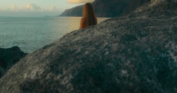 Задньому Плані Дівчина Сидить Позиції Лотоса Перед Великими Скелями Пляжу — стокове відео