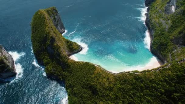 巴厘岛Nusa Penida Kelingking海滩的空中景观 岩石的形状是霸王龙 在印尼的一个著名的地方上空飞行 五彩缤纷的侏罗纪公园 有绿色的悬崖和深蓝色的海浪 — 图库视频影像