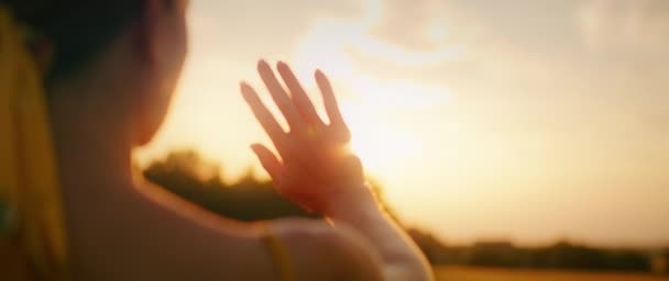 女人欣赏壮观的日落 女孩喜欢最后的阳光 她把她的手伸向天空 镜头照明弹 — 图库视频影像