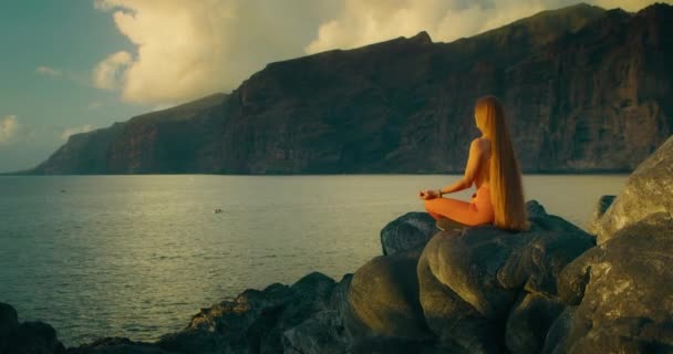 Жінка Практикує Йогу Медитує Положенні Лотоса Океанічному Скелястому Пляжі Вид — стокове відео