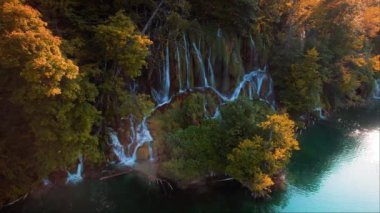 Şelale sonbahar ormanlarındaki birçok dereye akar ve göle akar. Parlak taze zümrüt suyu. Hırvatistan 'daki Plitvice Gölü Ulusal Parkı. Şelalenin havadan görünüşü ve parlak tatlı su