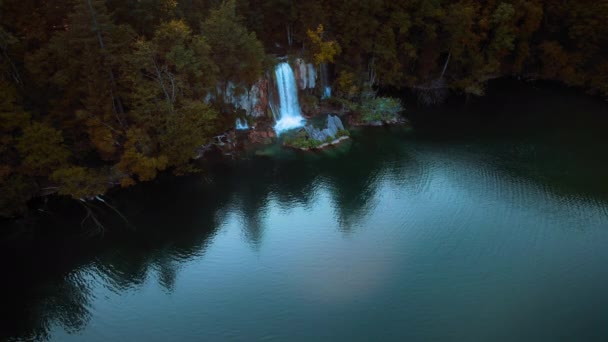 黑暗的森林景观 水流湍急的瀑布落入湖中 景致平静 暮色朦胧 克罗地亚Plitvice湖国家公园 从空中俯瞰瀑布流入翡翠淡水的景象 — 图库视频影像