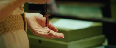 Kutuya bozuk para koyan birine yakın durmak, kiliseye gönüllü bağış yapmak. Ahşap haç tutan kadın günahlarının kefaretini ödemek için tapınağa geldi..