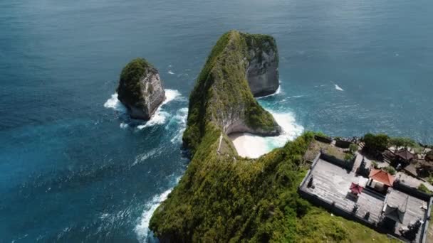 キリングビーチの空中ビュー インドネシアヌサペニダバリ島の深海の波を望むクリフサイド寺院 — ストック動画