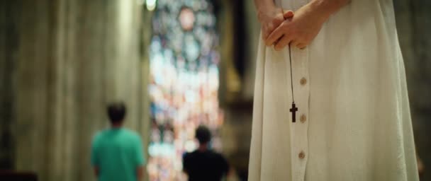 在旧教堂祈祷的女人成年女子教区管理员手里拿着一个宗教木制十字架 相信通过仁慈拯救 大教堂的升华 — 图库视频影像