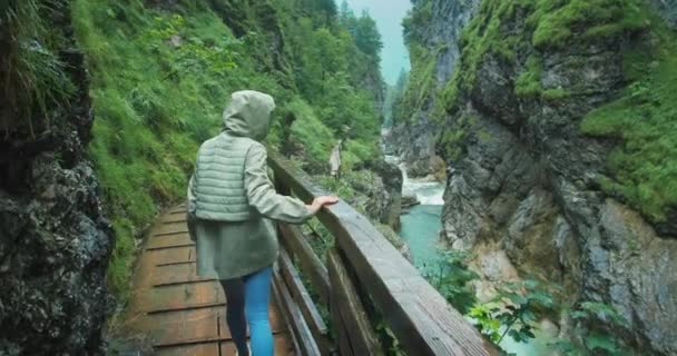 Wanita Menikmati Hujan Saat Mendaki Ngarai Berbatu Dengan Gunung Yang — Stok Video